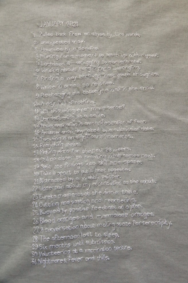 Embroidered panel of white stitching on grey cloth